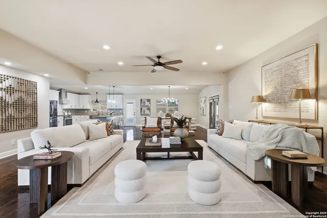 a living room with furniture kitchen view and a large window