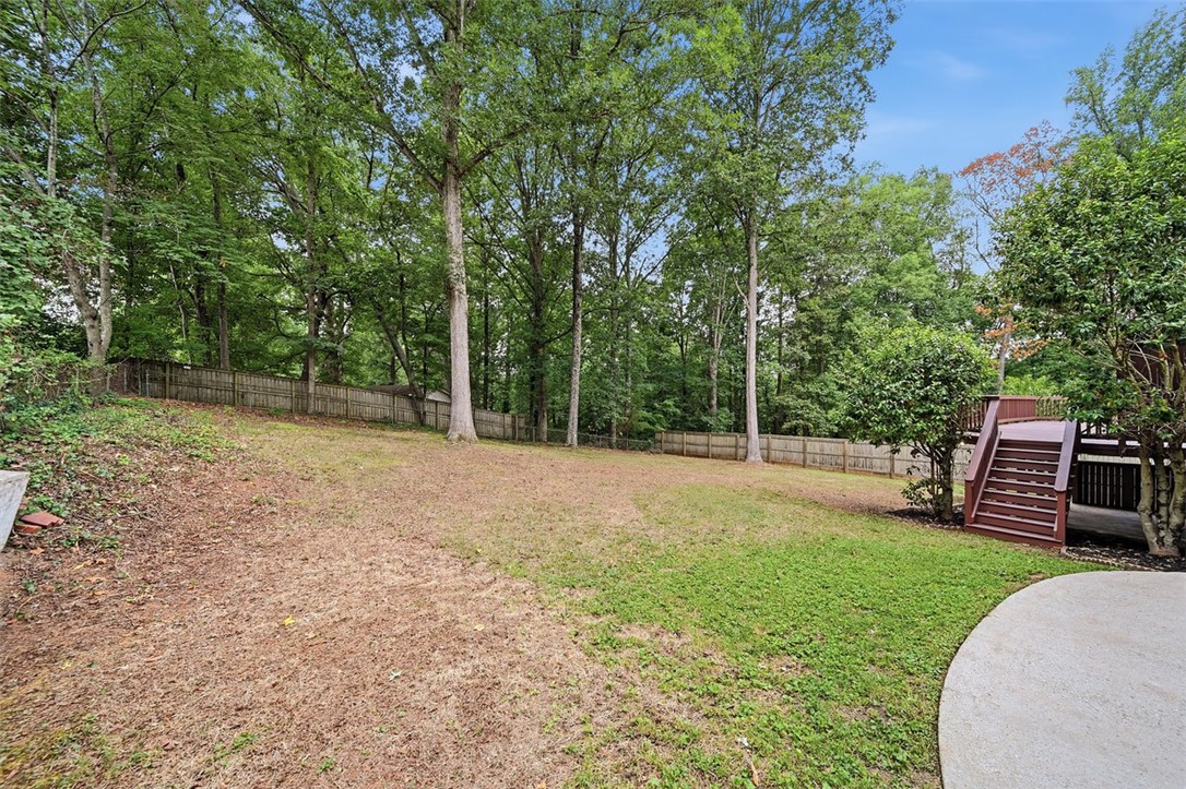 107 Edwards Mill Road Taylors, SC 29687 - Photo 28 of 34 A spacious backyard awaits, featuring a wooden deck with stairs and a full privacy fence.