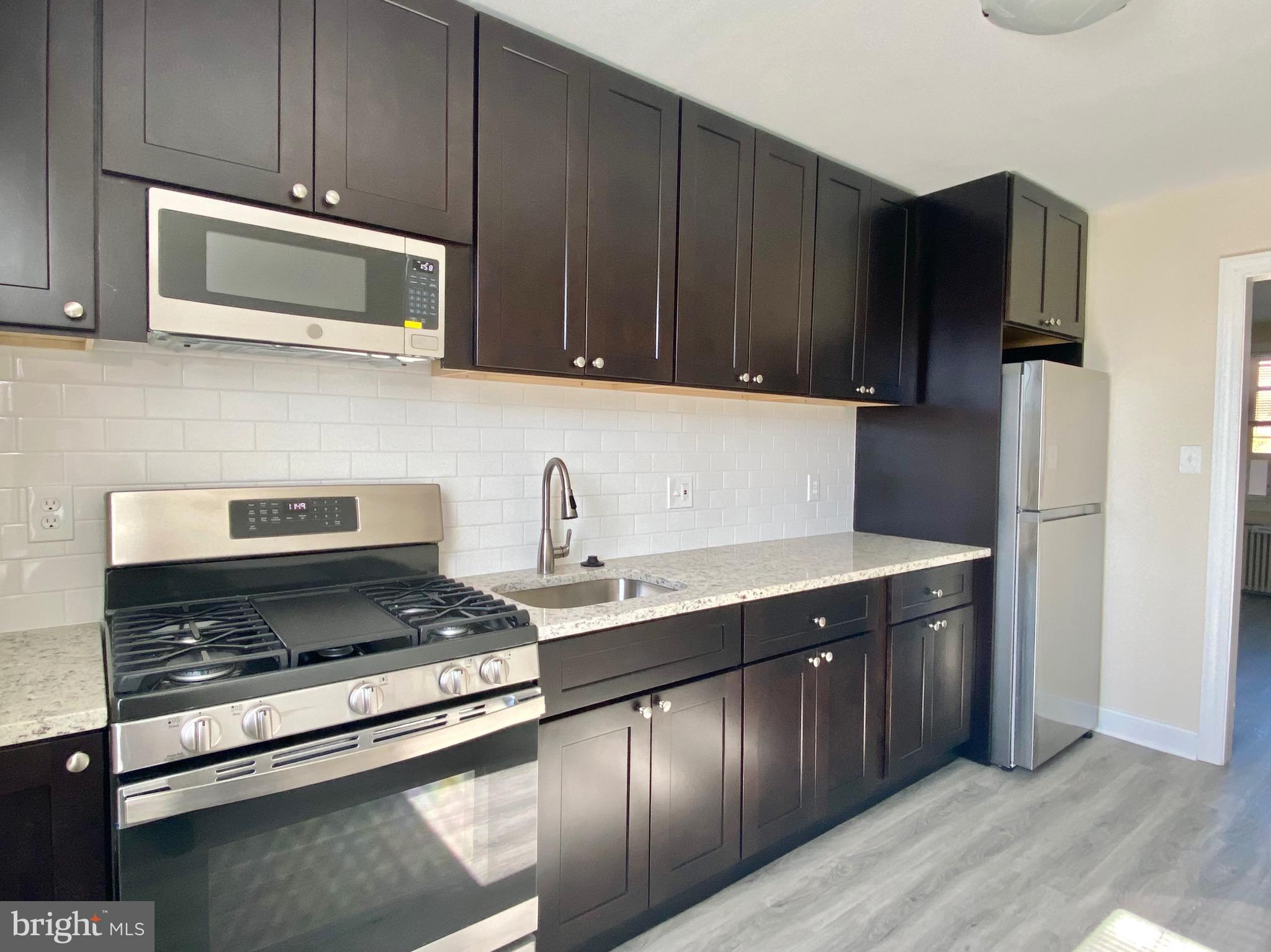 a kitchen with stainless steel appliances wooden cabinets and a stove top oven