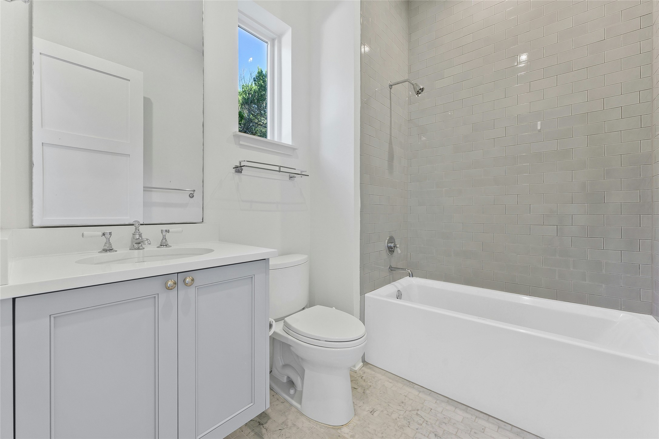 2518 Sutherland Street Austin, TX 78746 - Photo 28 of 30 A well-lit bathroom features a spacious vanity with an undermount sink and a sleek subway-tiled shower-tub combo.