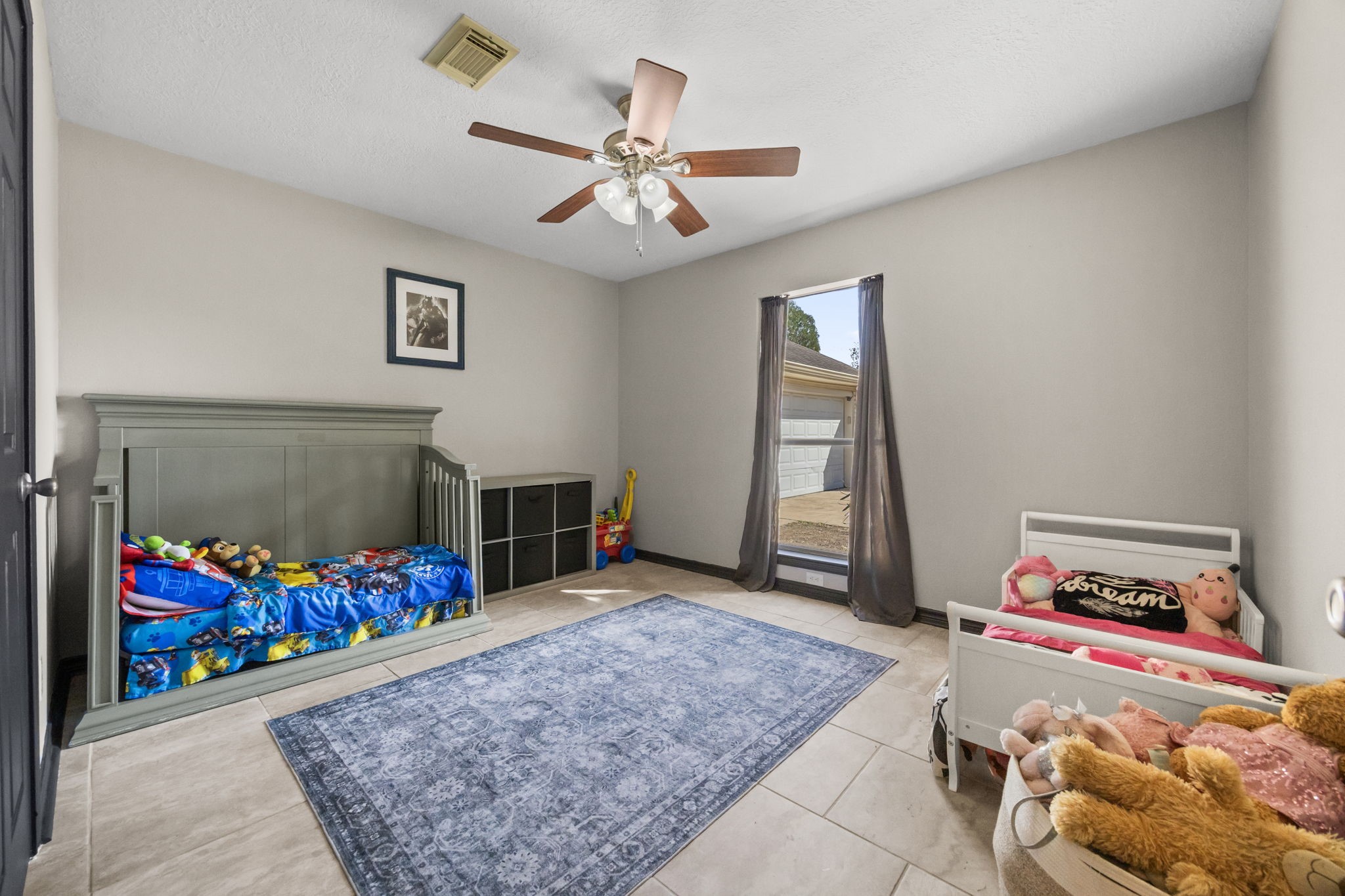 810 Hidden Canyon Road Katy, TX 77450 - Photo 24 of 33 This well-sized secondary bedroom features tile flooring, neutral paint tones, and a ceiling fan with light. The flexible layout easily accommodates a variety of furniture arrangements, making it suitable for guests, a home office, or a child’s room.