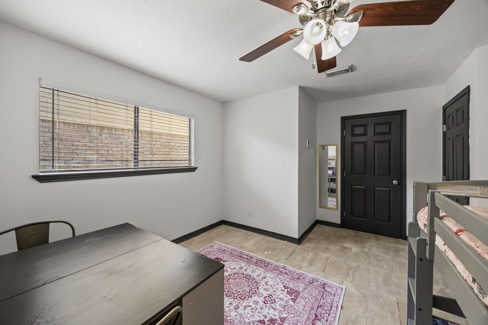 810 Hidden Canyon Road Katy, TX 77450 - Photo 25 of 33 Another secondary bedroom offers generous space, abundant natural light, and durable tile flooring. The room provides versatility for growing households or multi-use needs while maintaining a clean, cohesive design.
