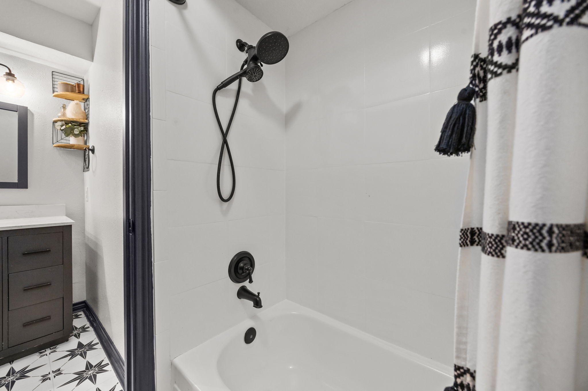 810 Hidden Canyon Road Katy, TX 77450 - Photo 27 of 33 The tub/shower combination is finished with crisp tile surround and a sleek black shower fixture, creating a fresh, modern look. Clean lines and thoughtful updates make this bathroom both practical and polished.
