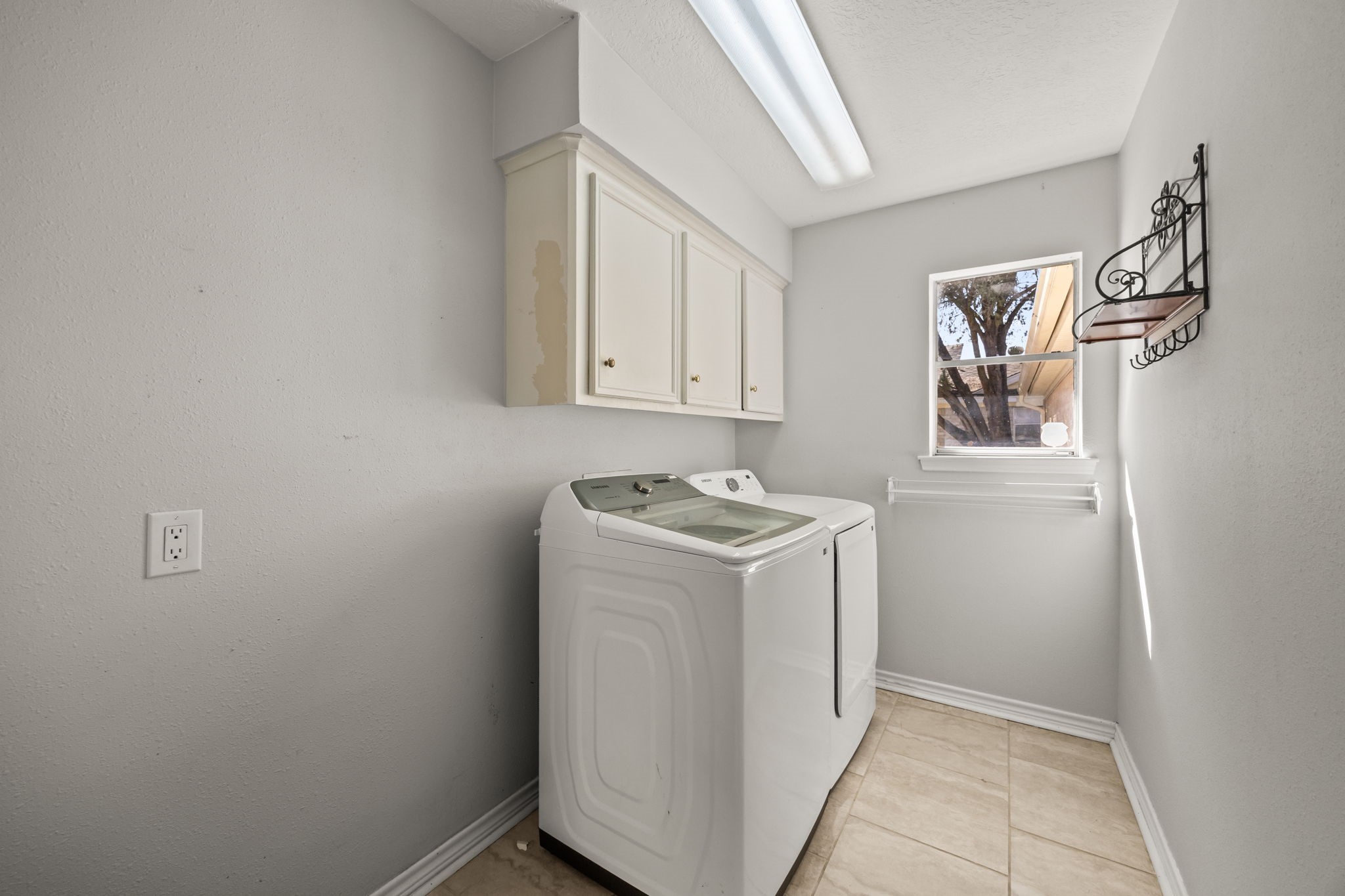 810 Hidden Canyon Road Katy, TX 77450 - Photo 28 of 33 The dedicated utility room offers space for full-size washer and dryer, upper cabinetry for storage, and tile flooring for easy maintenance. A window provides natural light, making everyday laundry tasks brighter and more convenient.