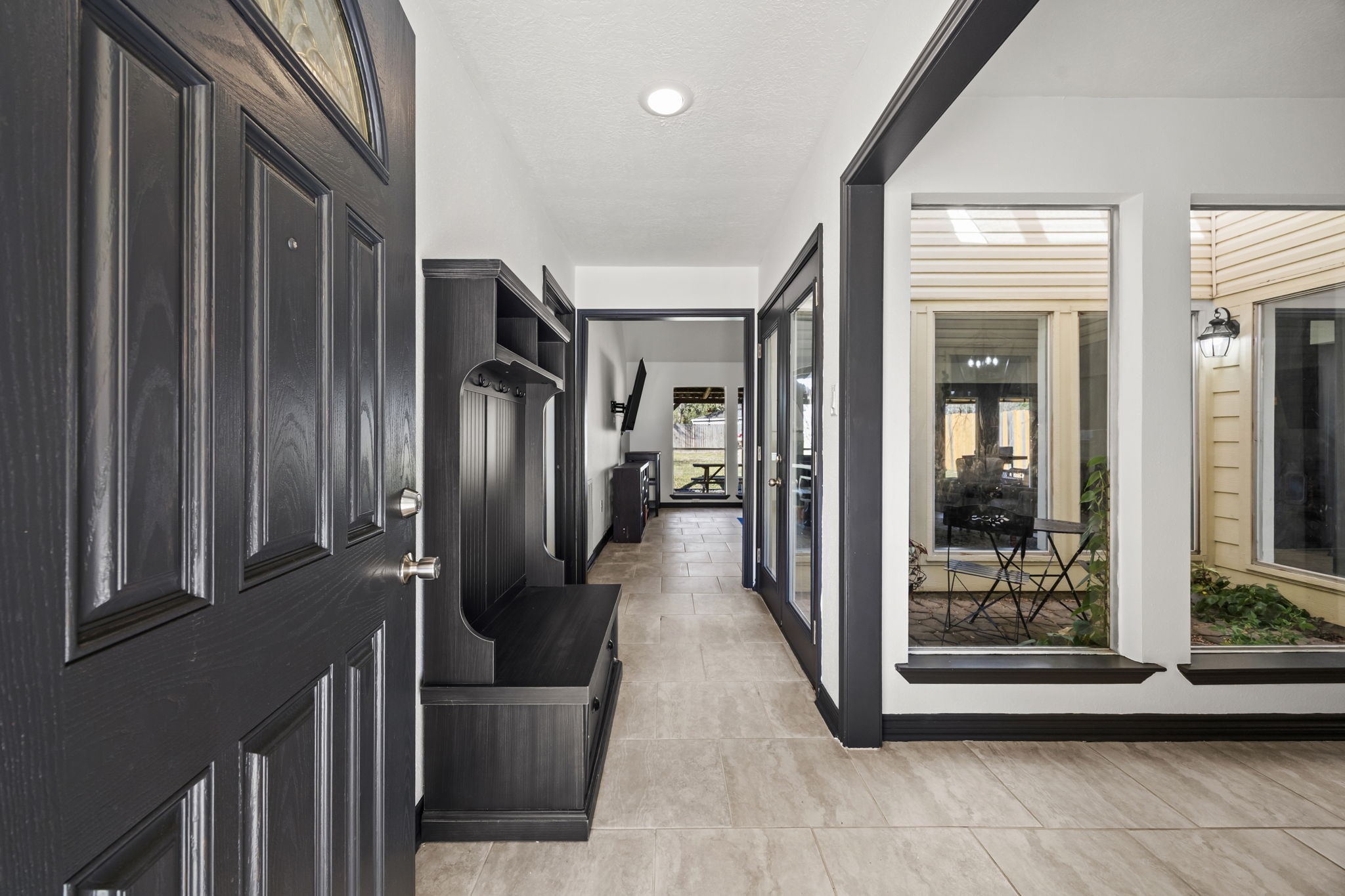 810 Hidden Canyon Road Katy, TX 77450 - Photo 3 of 33 A welcoming view from the entry showcases the home’s clean, modern aesthetic with tile flooring, crisp white walls, and bold black trim.