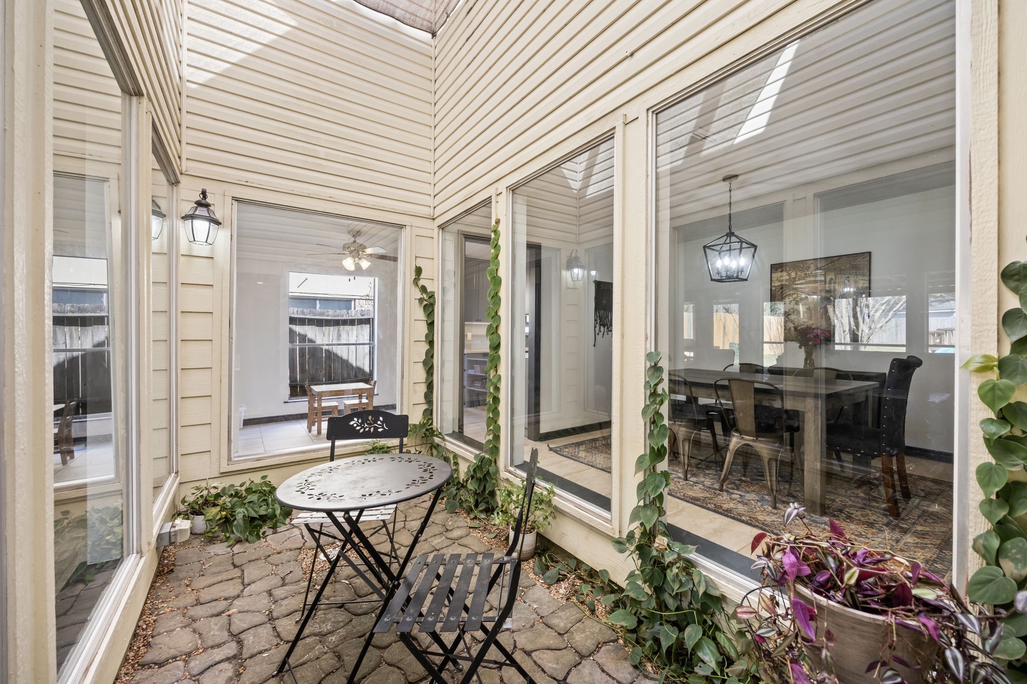 810 Hidden Canyon Road Katy, TX 77450 - Photo 5 of 33 This charming enclosed atrium offers a peaceful outdoor retreat surrounded by walls of windows, allowing natural light to pour into the surrounding living spaces. Paver flooring, climbing greenery, and space for café seating create a tranquil setting ideal for morning coffee or quiet relaxation.