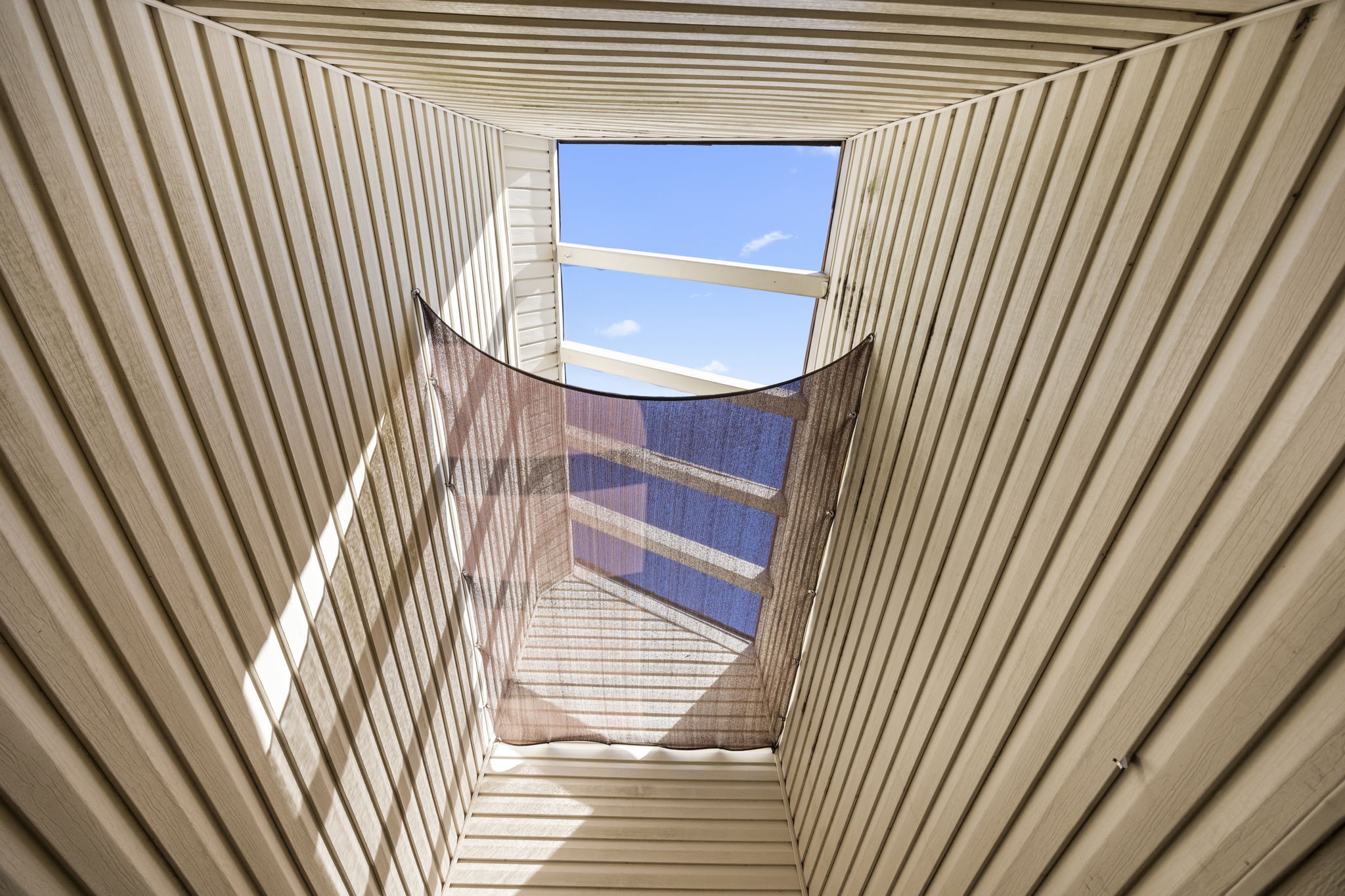 810 Hidden Canyon Road Katy, TX 77450 - Photo 6 of 33 Looking upward, the atrium skylight brings in abundant natural light. Open beams create visual interest, enhancing the home’s unique indoor-outdoor connection and filling adjacent rooms with soft daylight.