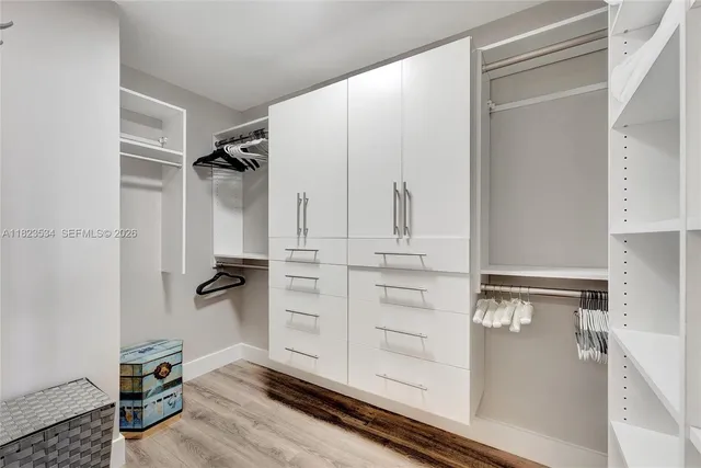 a view of walk in closet with clothes and shoes