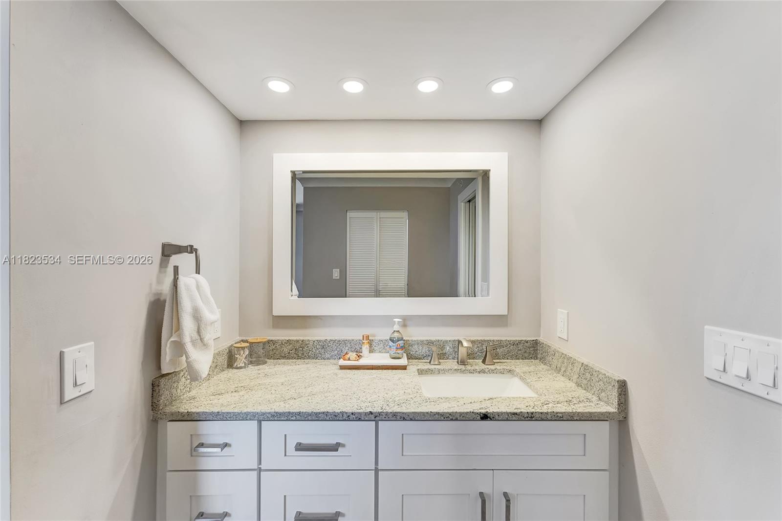 200 Ocean Trail Way, Unit 701 Jupiter, FL 33477 - Photo 34 of 40 a bathroom with a granite countertop sink and a mirror