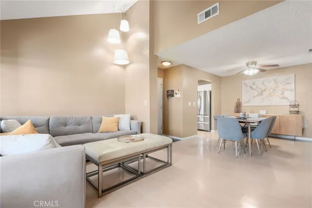 a living room with furniture a dining table and chairs with chandelier