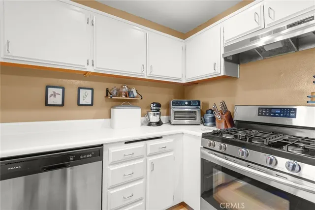 a kitchen with stainless steel appliances granite countertop a refrigerator and a stove