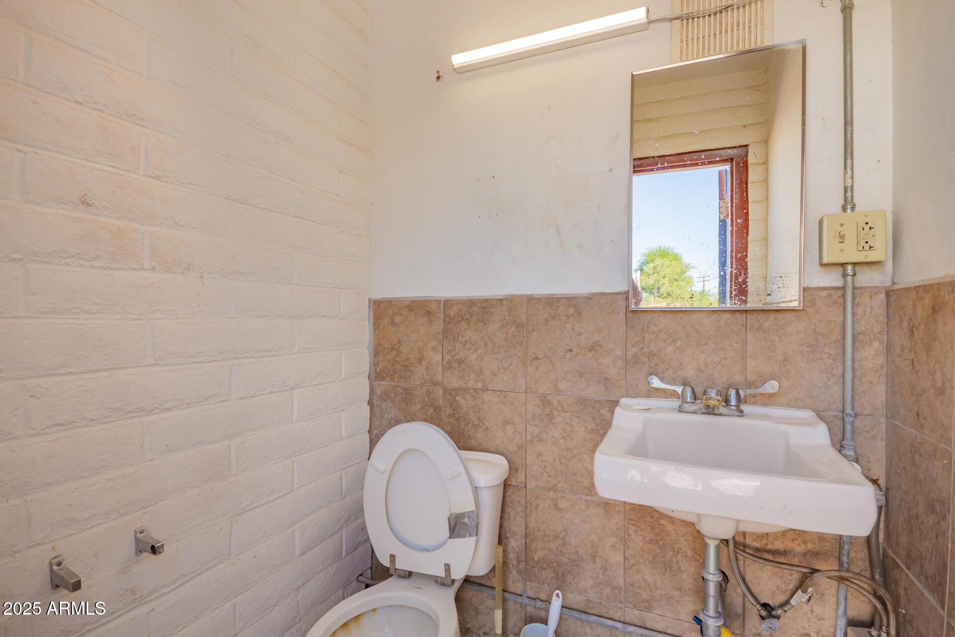 2925 East Ganley Road, Unit 121 Tucson, AZ 85706 - Photo 44 of 45 a bathroom with a toilet a sink and mirror