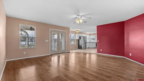 a view of an empty room with a window and wooden floor
