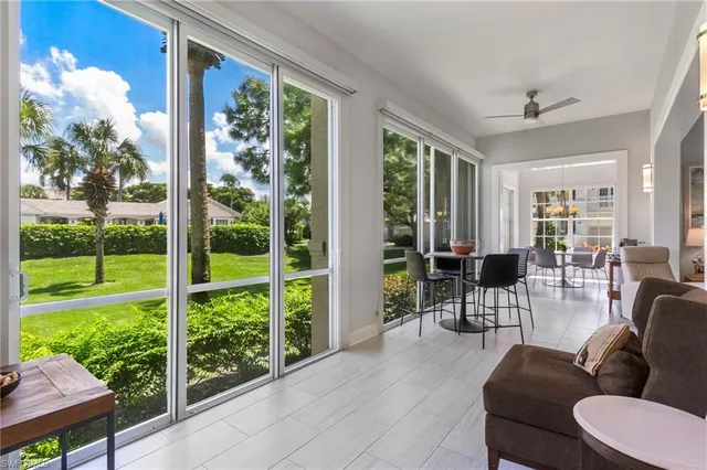 a living room with furniture and a floor to ceiling window