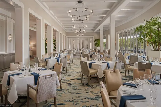 a view of a dining room with furniture a chandelier and large windows