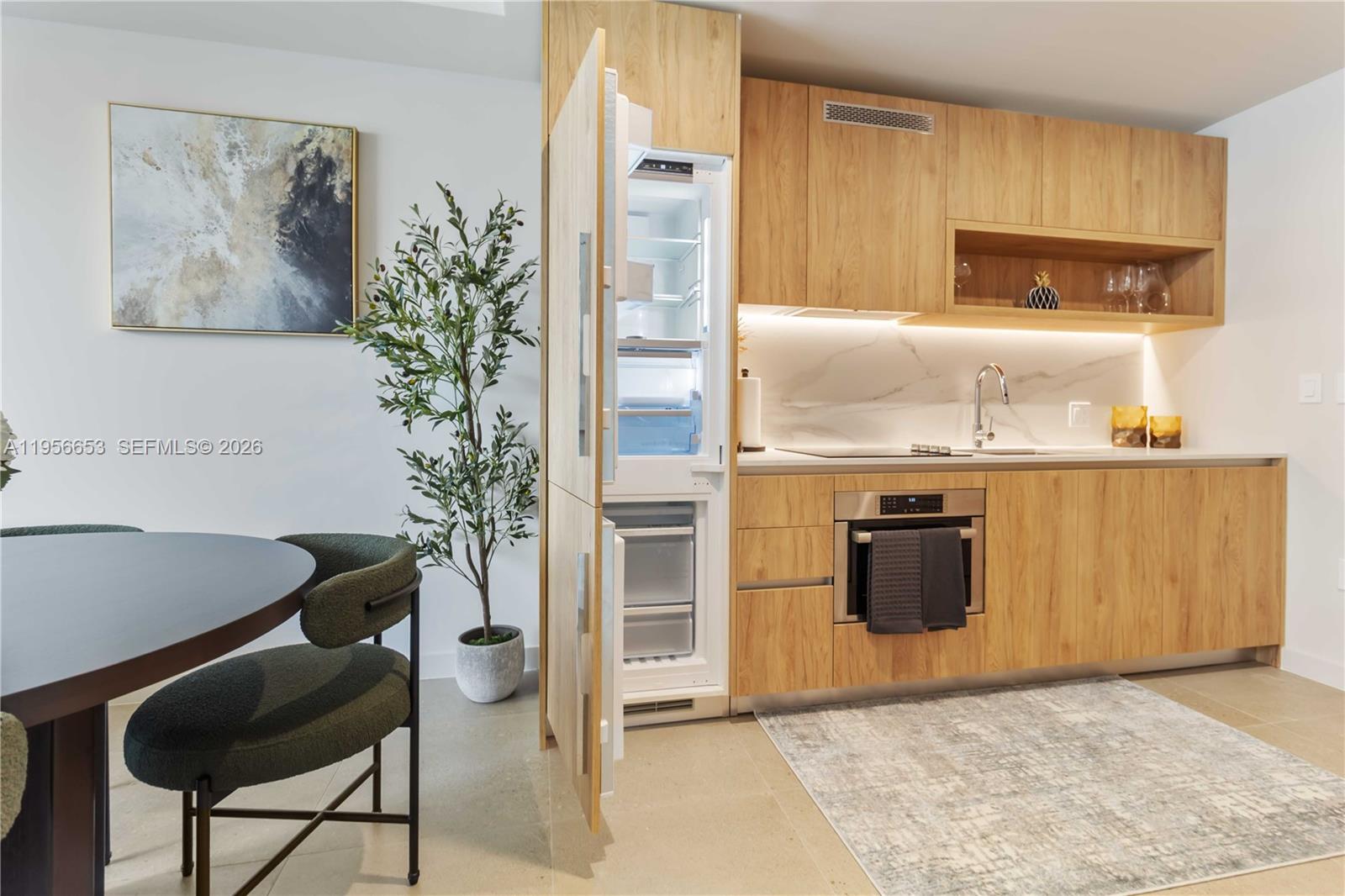 11 Northeast 6th Street, Unit 1513 Miami, FL 33132 - Photo 4 of 44 a kitchen with granite countertop a refrigerator and a stove