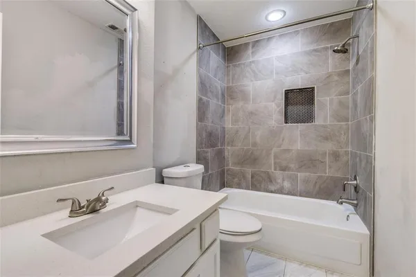 a bathroom with a sink mirror toilet and bathtub
