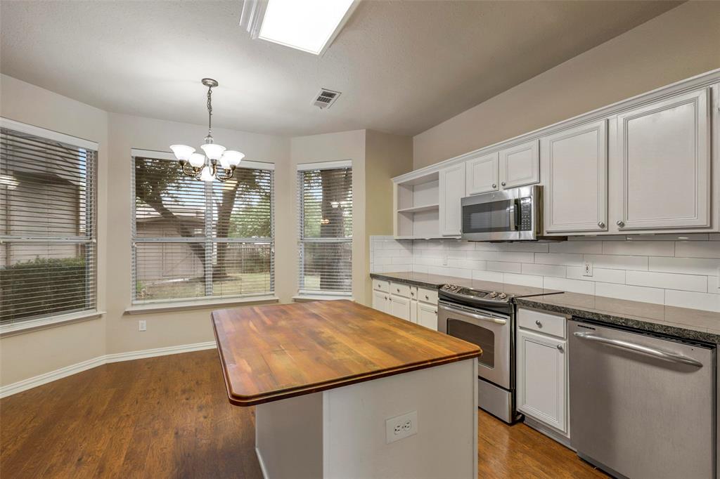 a kitchen with stainless steel appliances granite countertop a sink and a microwave