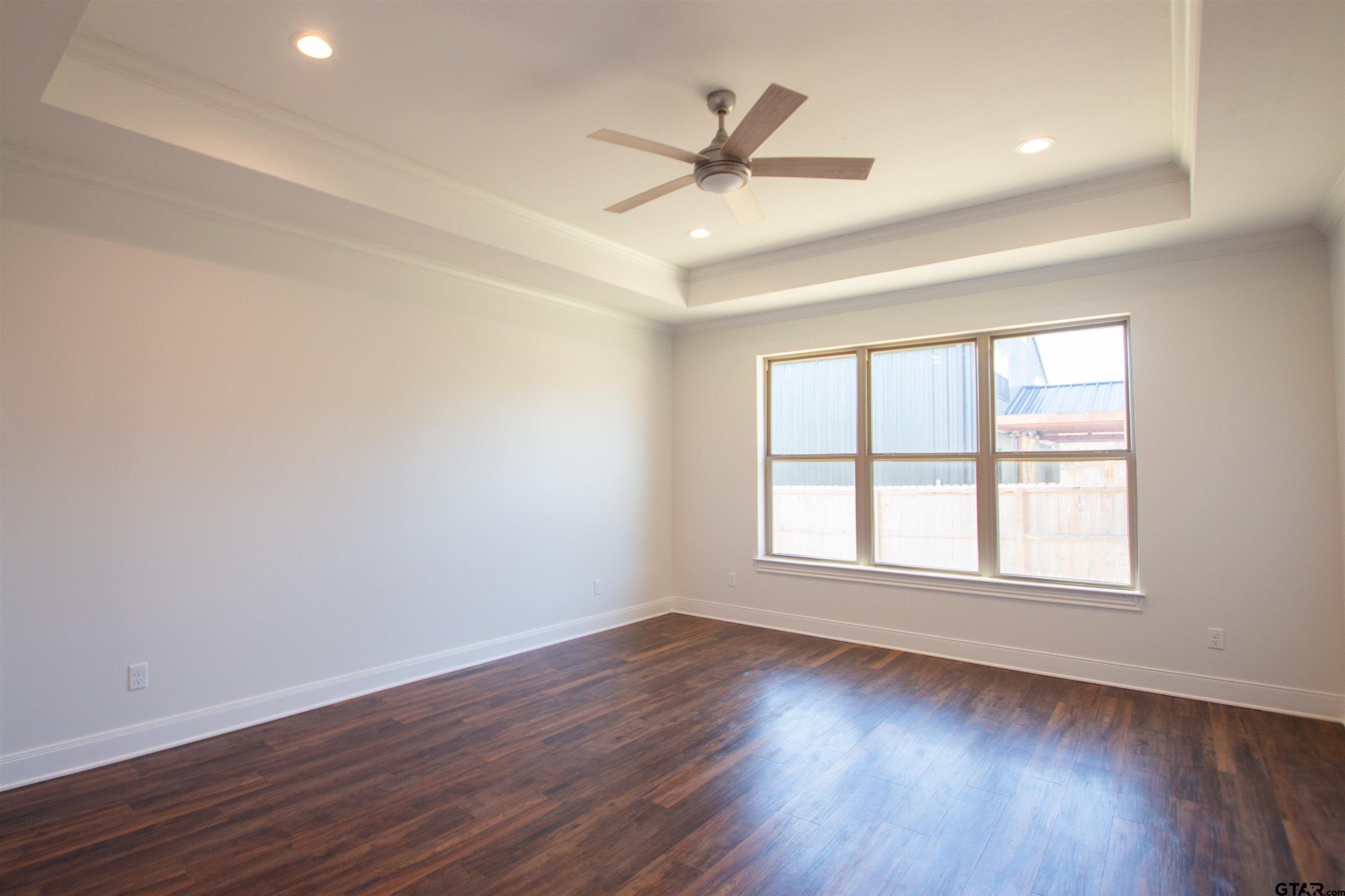 14716 Fallow Lane Tyler, TX 75706 - Photo 13 of 46 an empty room with wooden floor fan and windows