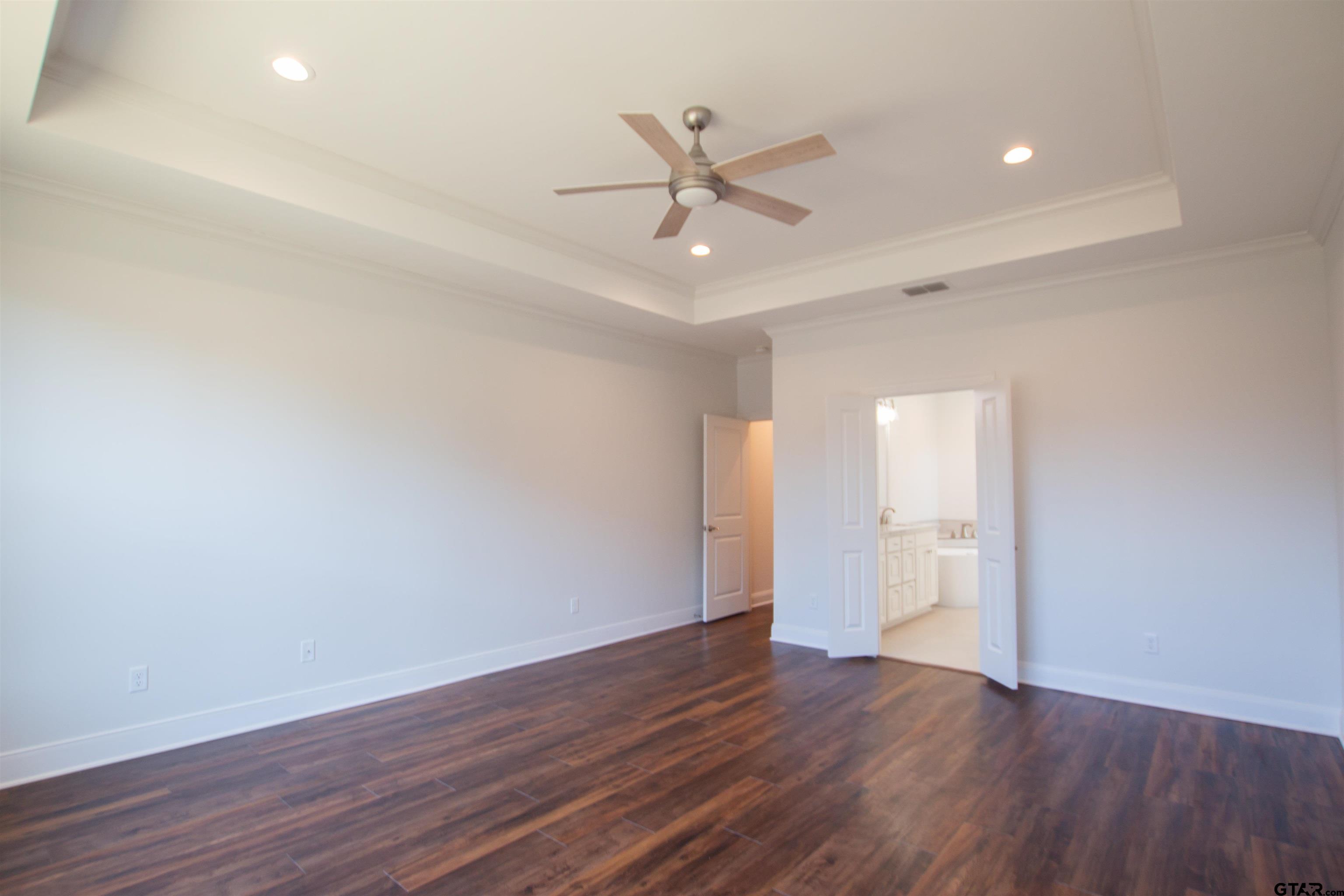 14716 Fallow Lane Tyler, TX 75706 - Photo 14 of 46 a view of an empty room with wooden floor and a ceiling fan