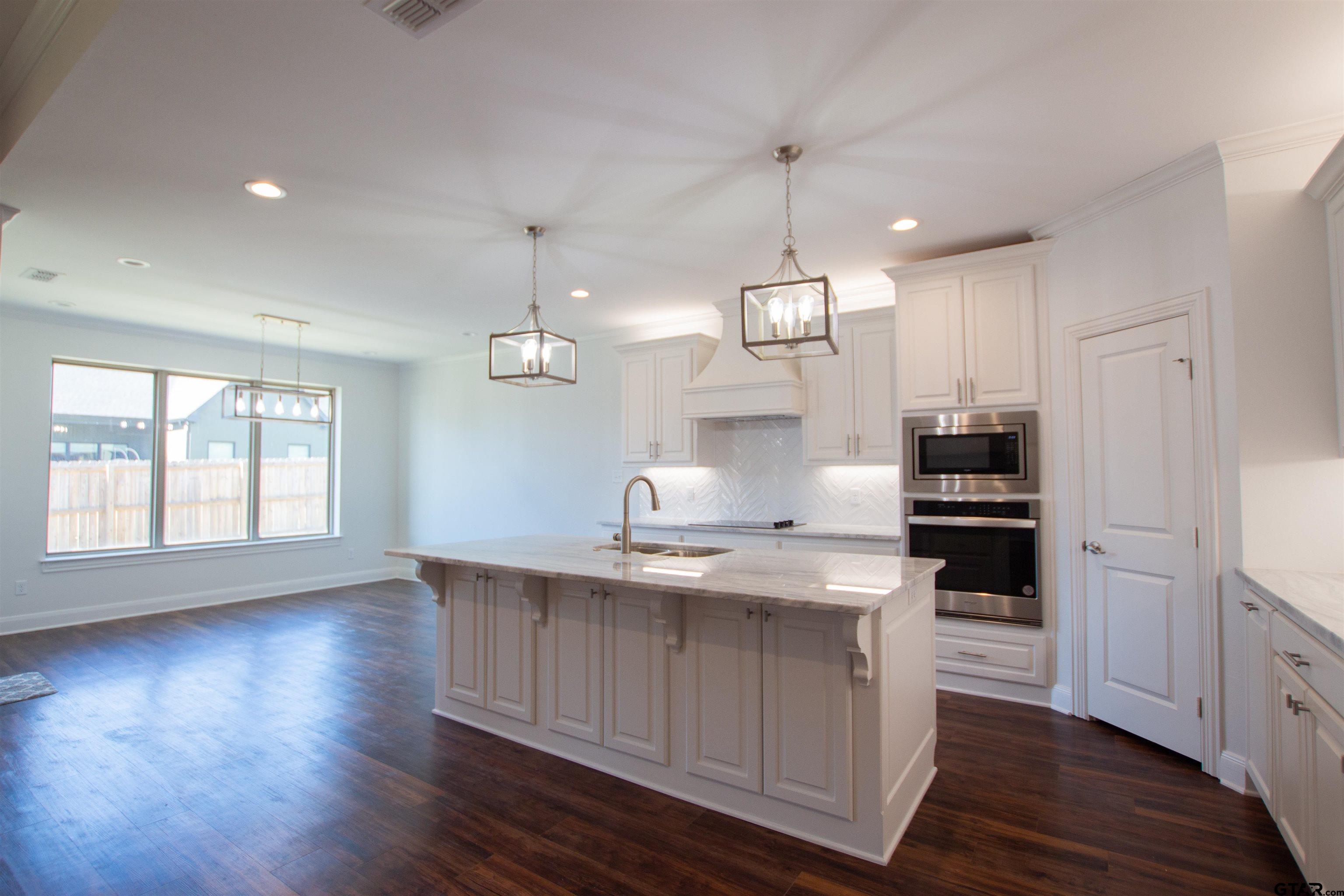 14716 Fallow Lane Tyler, TX 75706 - Photo 7 of 46 a kitchen with kitchen island granite countertop a sink cabinets and wooden floor