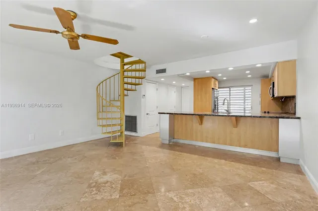 a kitchen with granite countertop white cabinets and stainless steel appliances