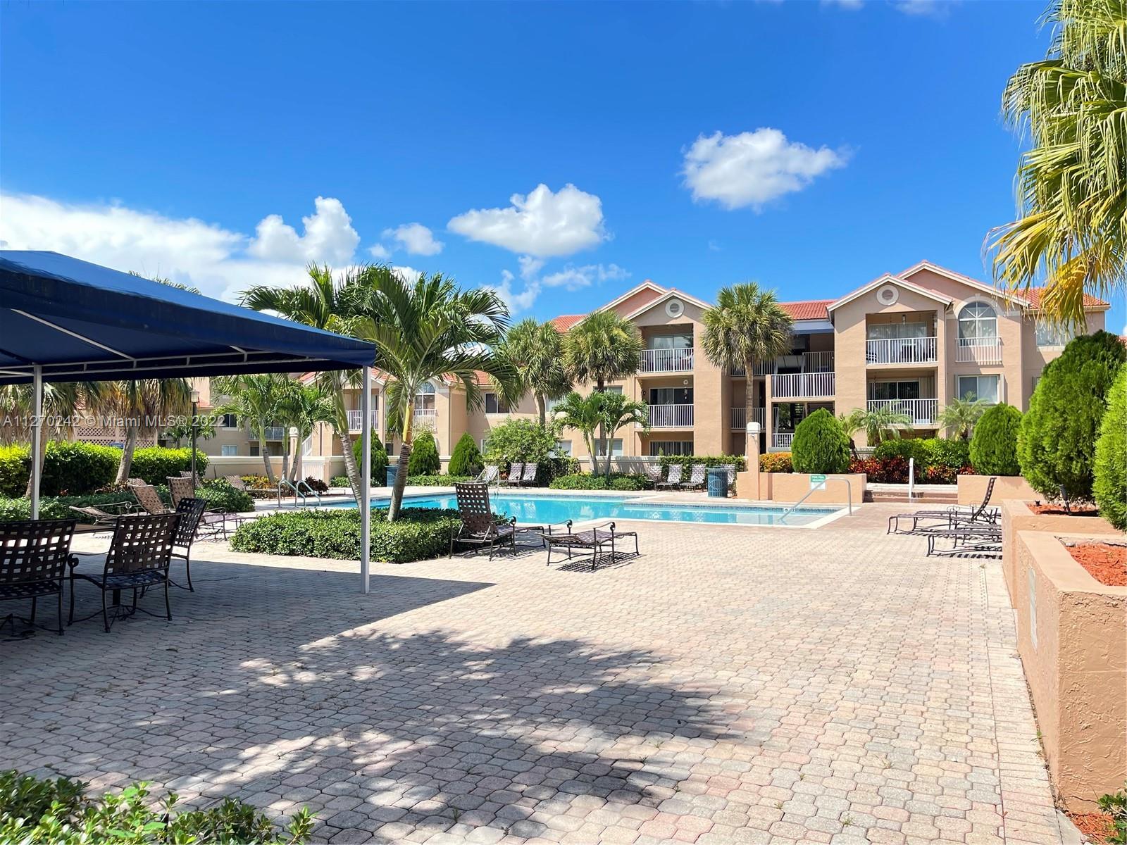 The Hammocks Miami, FL 33196 - Photo 19 of 21 a view of a patio with a table and chairs under an umbrella