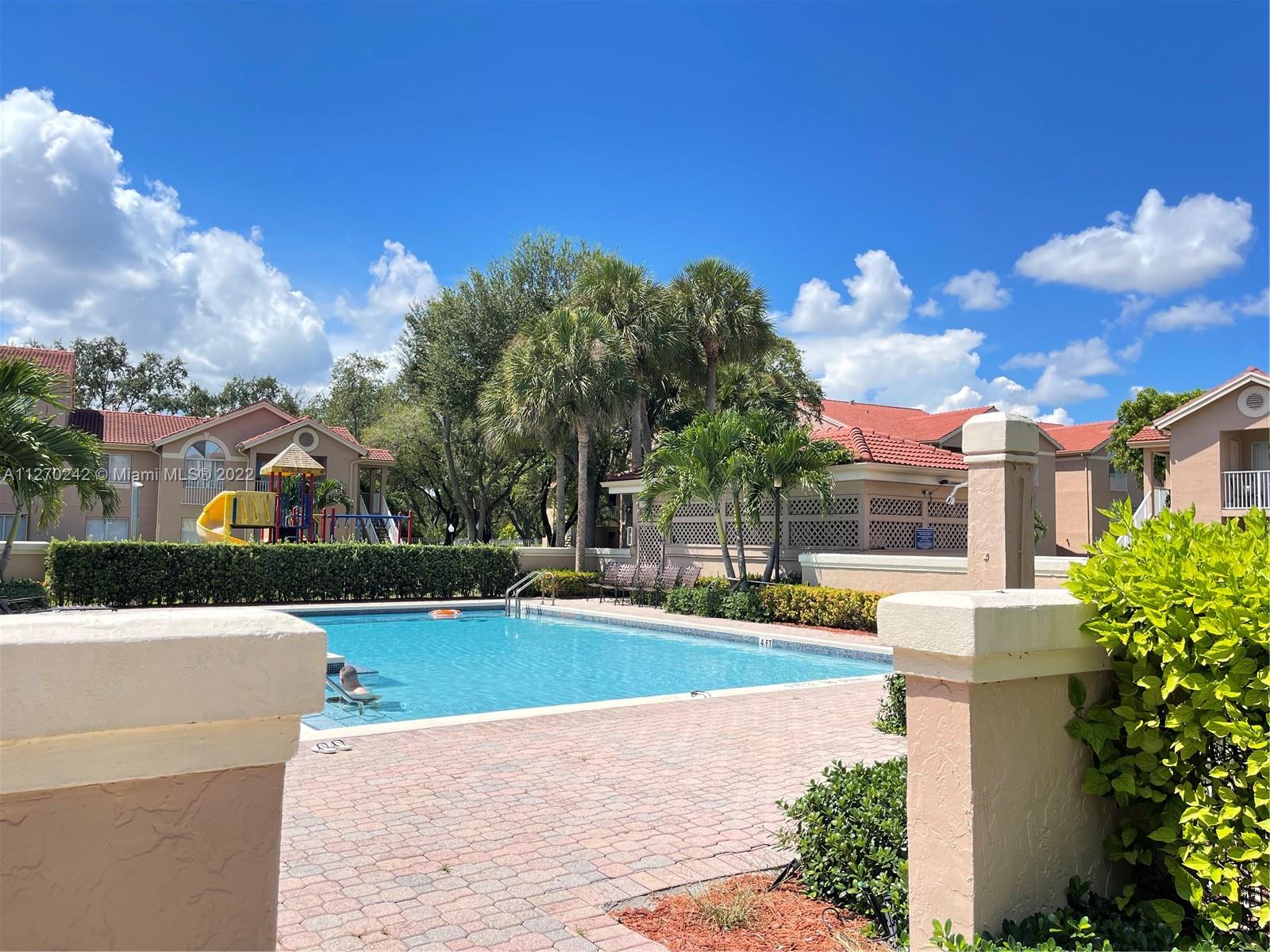 The Hammocks Miami, FL 33196 - Photo 20 of 21 a view of a white house with a swimming pool and outdoor seating