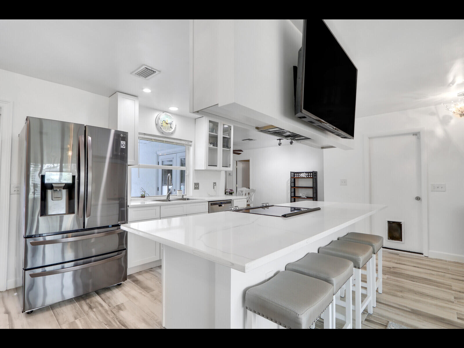 609 Oak Terrace Jupiter, FL 33458 - Photo 13 of 28 a kitchen with stainless steel appliances kitchen island granite countertop a refrigerator oven a sink dishwasher and a refrigerator with wooden floor