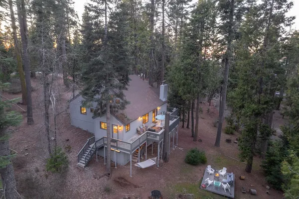 a view of house with outdoor space and trees in the background