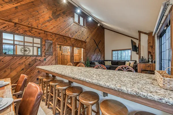 a kitchen with stainless steel appliances granite countertop wooden cabinets a stove top oven a sink and dishwasher with wooden floor