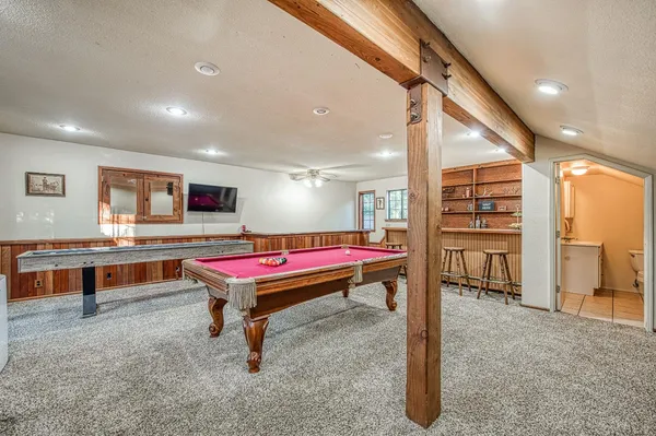 a room with furniture pool table and windows