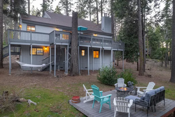 a view of a house with backyard and trees