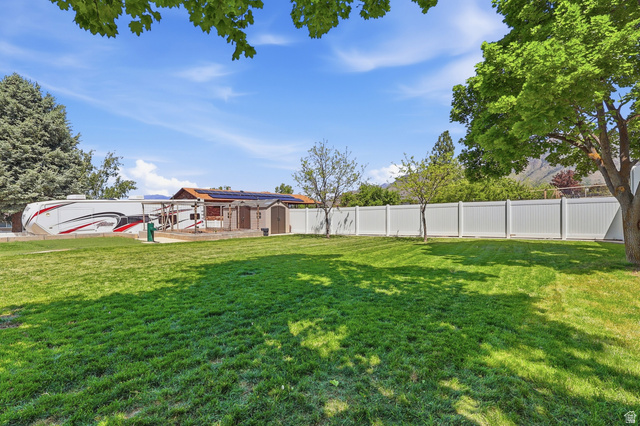 114 North Clark Lane Elk Ridge, UT 84651 - Photo 25 of 26 Expansive green lawn with a white privacy fence