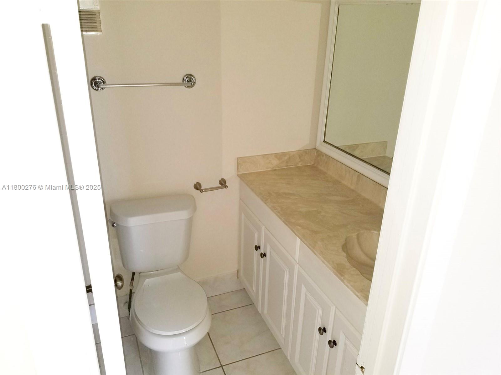 8560 Sherman Circle North, Unit 402 Miramar, FL 33025 - Photo 10 of 19 a bathroom with a granite countertop toilet and a sink