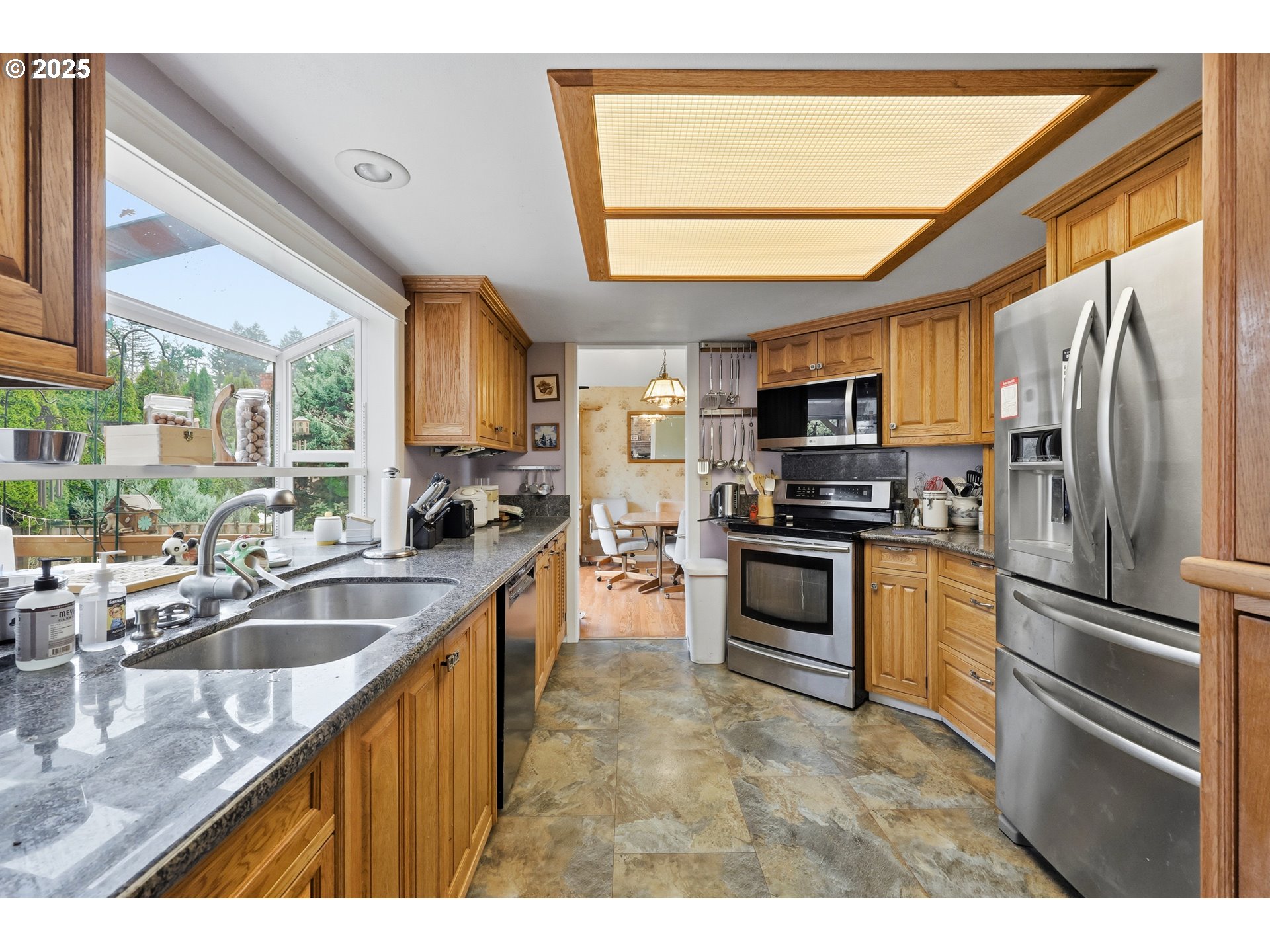 3749 Southwest 6th Street Gresham, OR 97030 - Photo 14 of 41 a kitchen with stainless steel appliances granite countertop a refrigerator a sink dishwasher a stove and a microwave oven with wooden floor