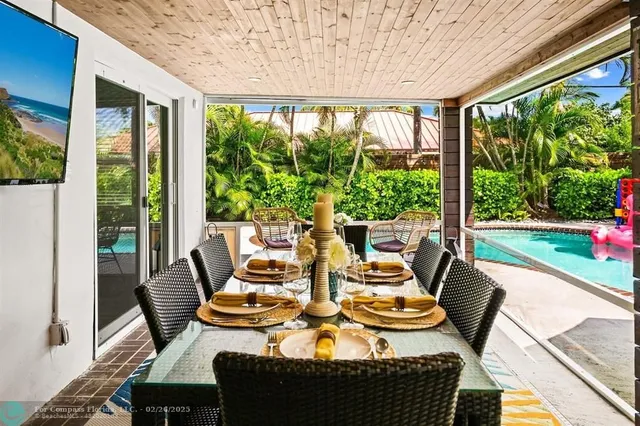 a dining room with furniture a large window and a yard