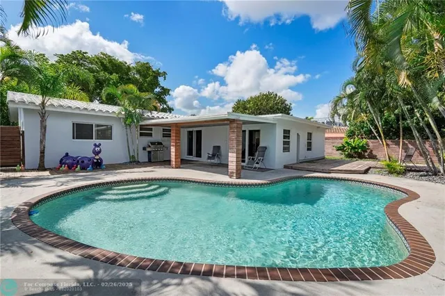 a view of a house with swimming pool and sitting area