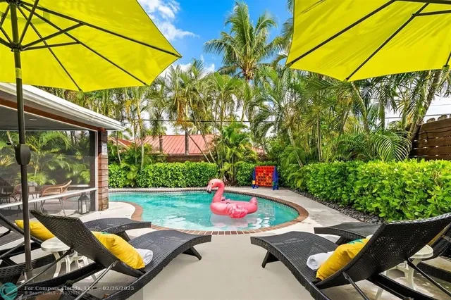a view of a backyard with table and chairs under an umbrella
