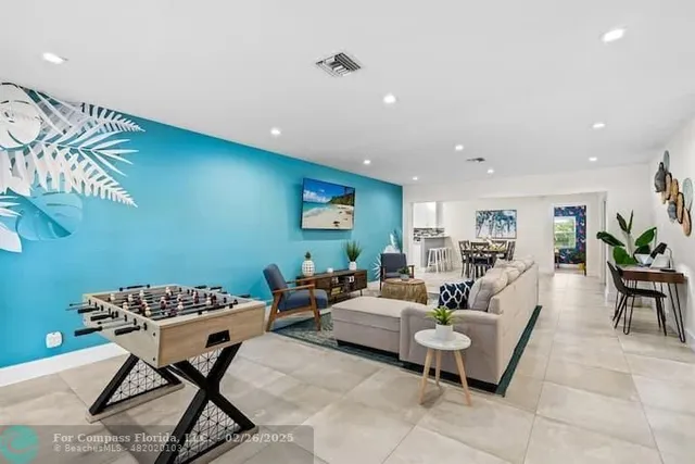 a living room with couches and a dining table with wooden floor