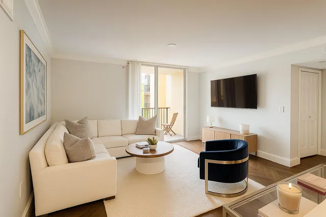 a living room with furniture a flat screen tv and a window