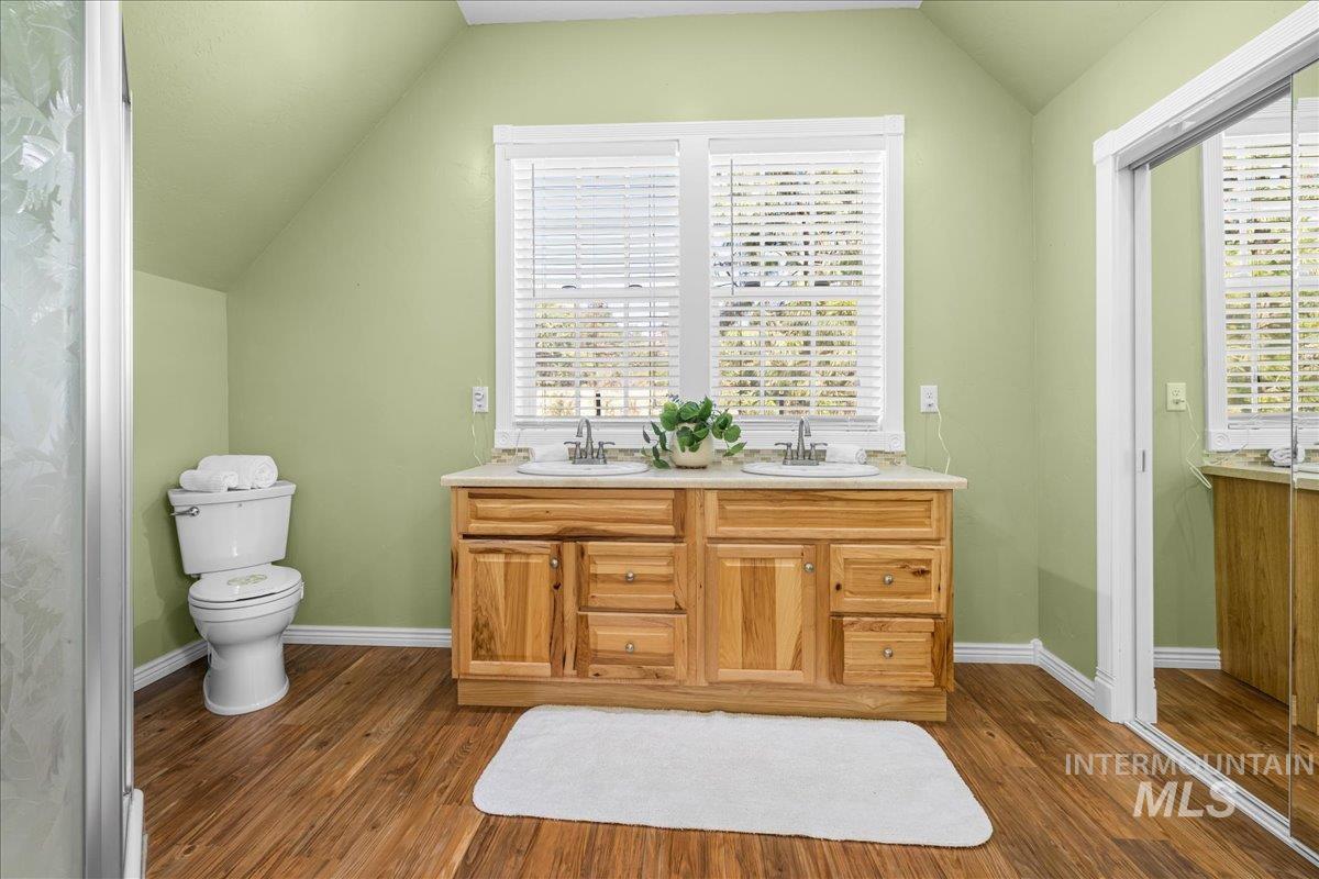5611 West Hill Road Boise, ID 83703 - Photo 23 of 48 Bathroom with vaulted ceiling, double vanity, and dark wood-style floors