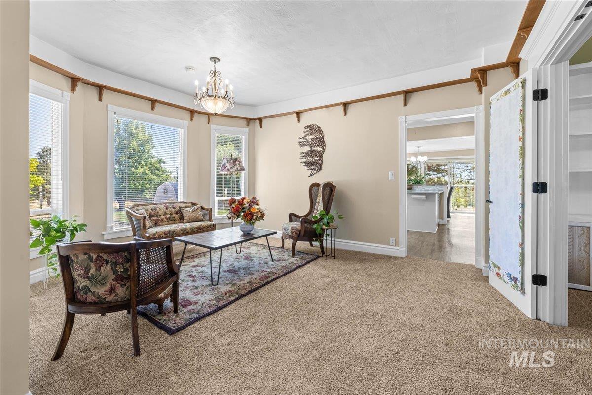 5611 West Hill Road Boise, ID 83703 - Photo 7 of 48 Carpeted sitting room with a chandelier and healthy amount of natural light