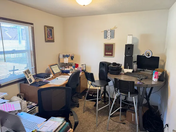 a view of a workspace with furniture and a window