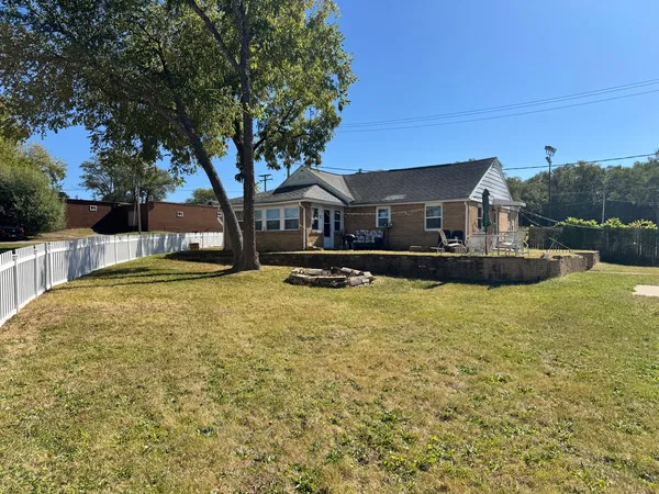 a front view of a house with a yard fountain and large tree