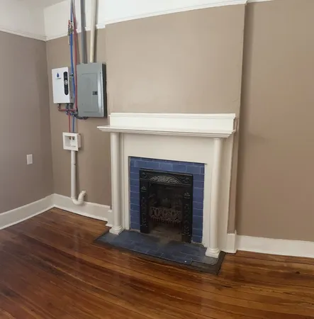 a view of empty room with wooden floor and fireplace