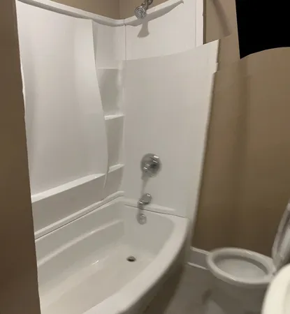 a white bath tub sitting next to a white toilet