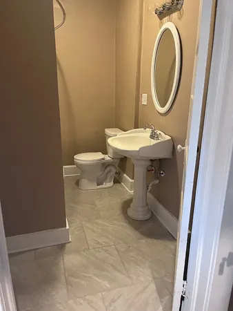 a bathroom with a sink a toilet and a mirror