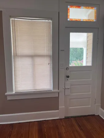 a view of a small space with wooden floor and a window