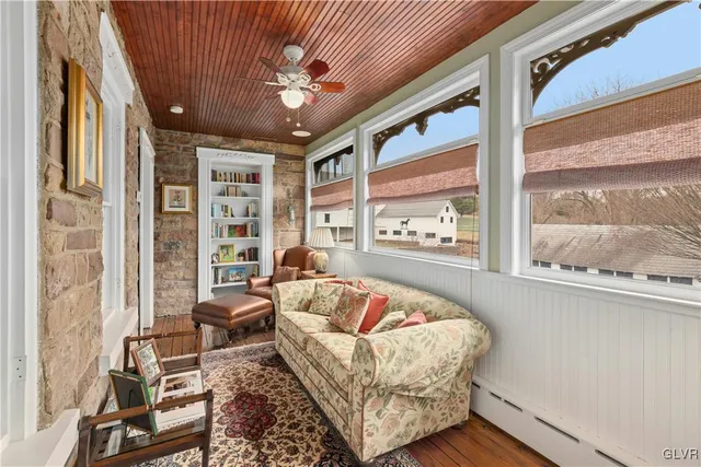 a living room with a black white checkered floor with a gaming machine and dining chairs